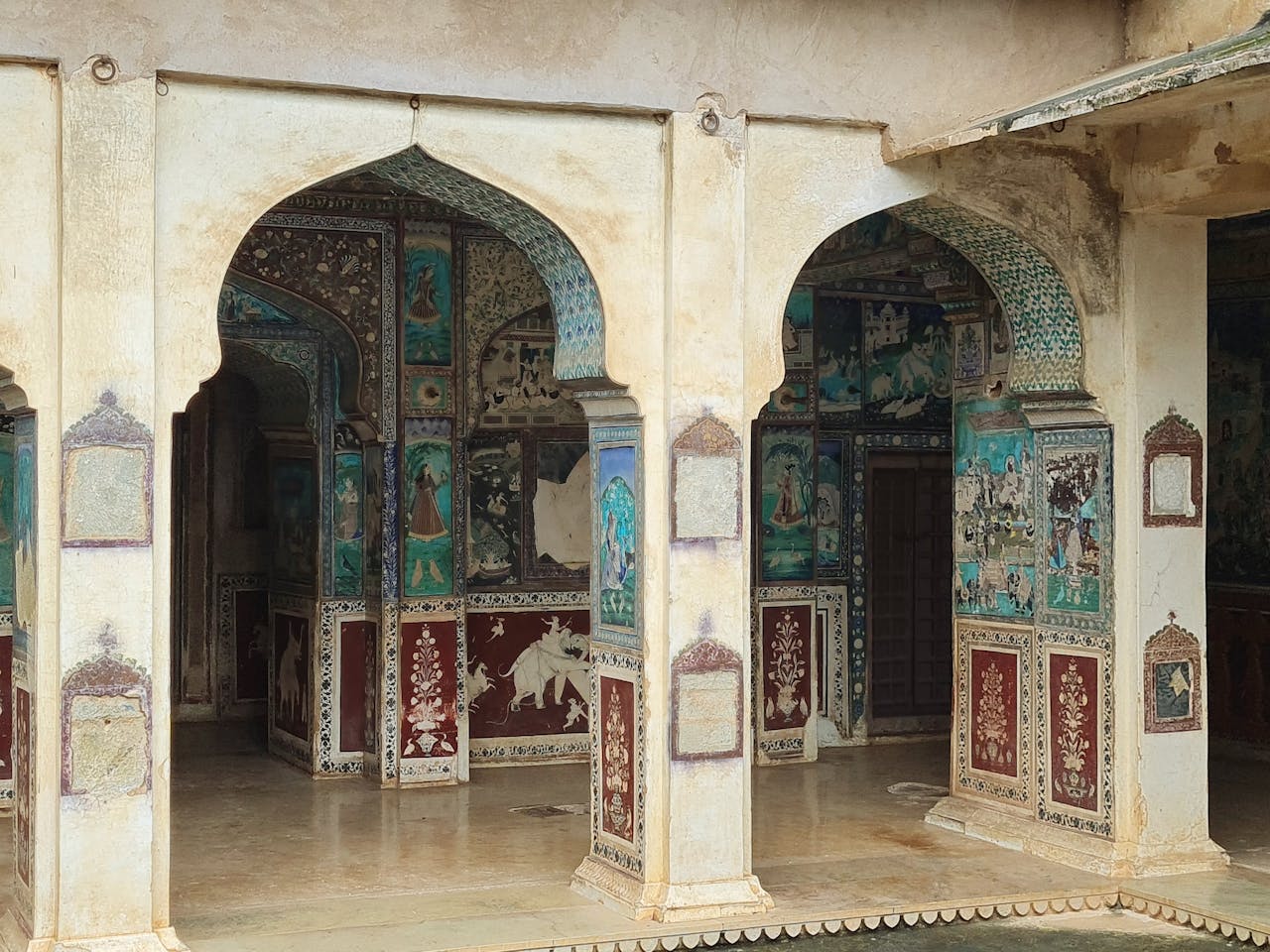 Intricate murals on palace arches in Bundi, India showcasing traditional art and architecture.