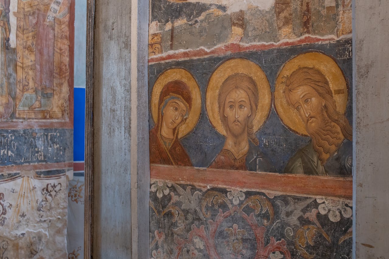 Detailed view of a medieval religious fresco featuring iconic Christian saints in a historic church.